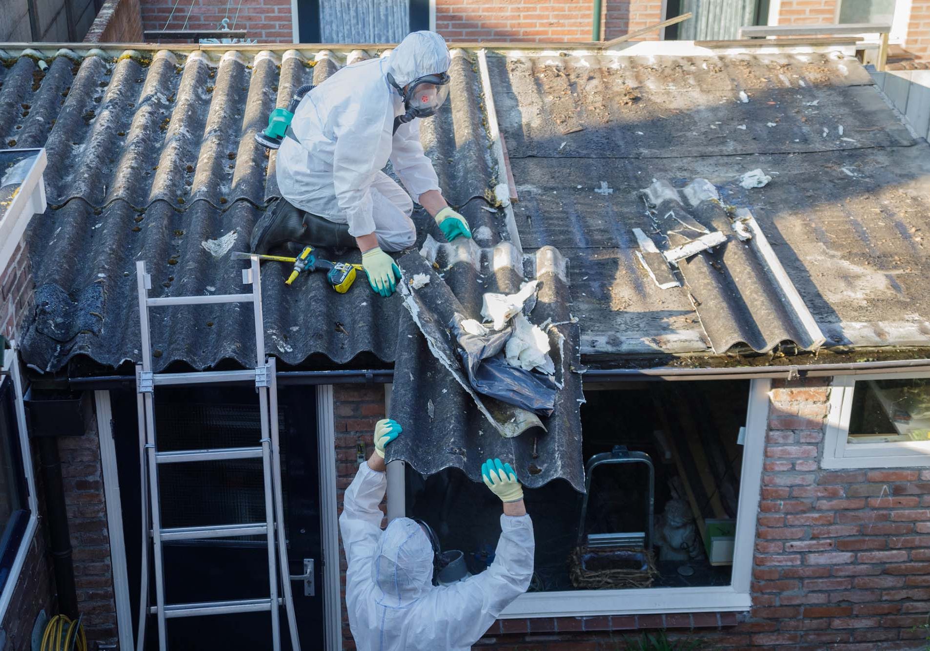 Professional asbestos removal. Men in protective suits are removing asbestos cement corrugated roofing
